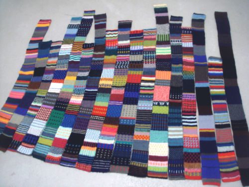 Am Boden ausgelegte, lange gestrickte Bahnen mit bunten Streifen und Mustern
