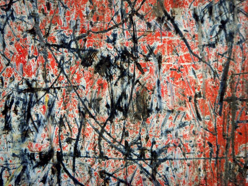 Rot-weisse Fläche, übersät mit dunklen, sich kreuzenden Kratz- und Farbspuren, Nahaufnahme, Fotografie aus der Serie «Alltägliche Fundstücke II»