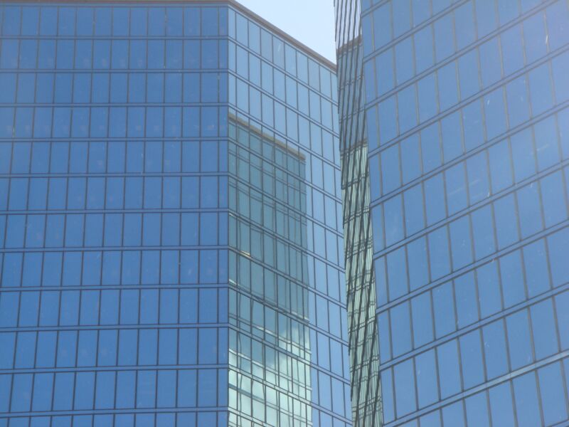 Ausschnitt zweier blauer Glasfassaden, deren Kanten sich überlagern und spiegeln, Fotografie aus der Serie «Honolulu»