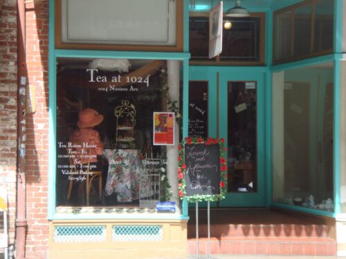 Türkis gerahmtes Schaufenster eines Teesalons «Tea at 1024» mit Hut, Stuhl und Kreidetafel vor dem Eingang, Fotografie aus der Serie «Honolulu»
